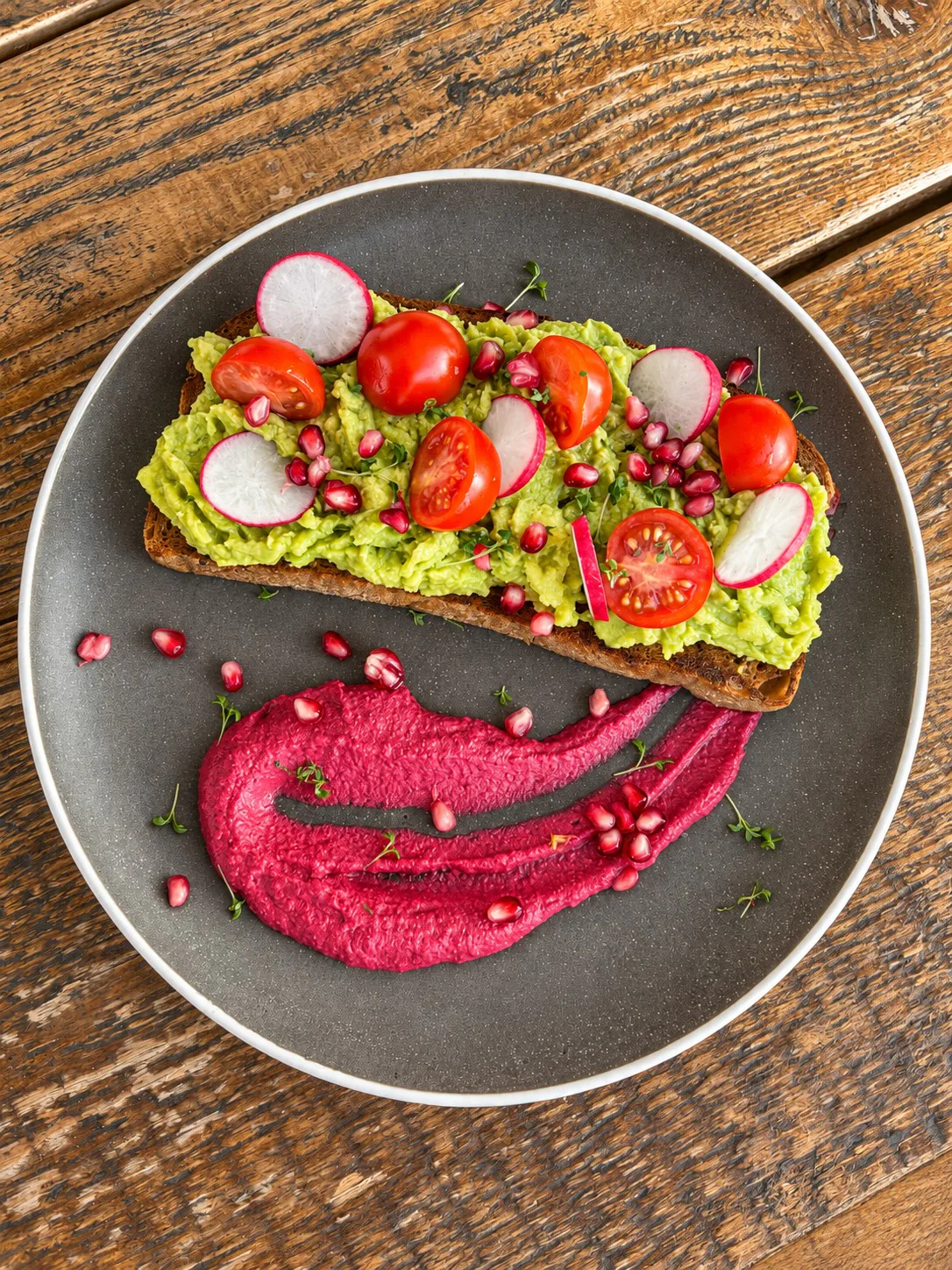 Avocado-Toast mit Tomaten und Radieschen auf einem Teller